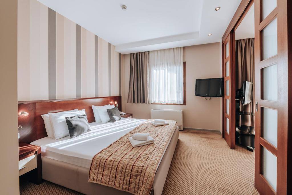 Bedroom with striped walls and a flat-screen TV